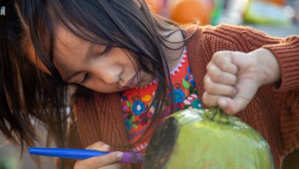 Child painting pumpkin