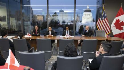 Legislators with delegation member, seated at table