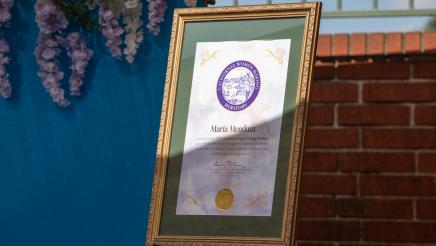 Framed certificate on stand, honoring Maria Mendoza
