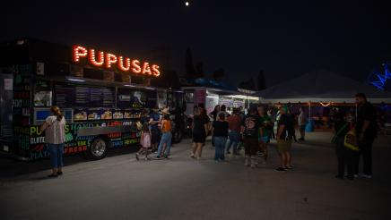 Attendees gather close to food trucks