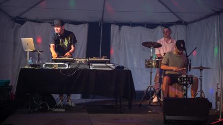 DJ and drummers performing onstage