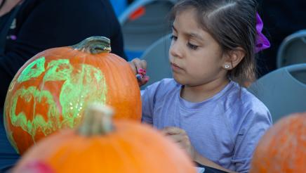 Child painting pumpkin