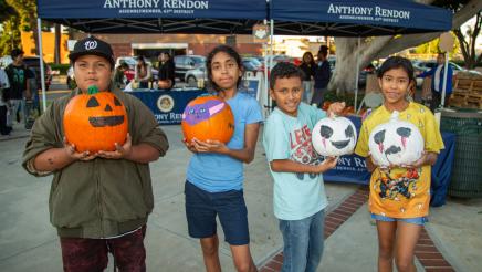 Kids holding painted pumpkins
