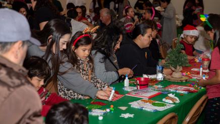 Families at tables, working on crafts