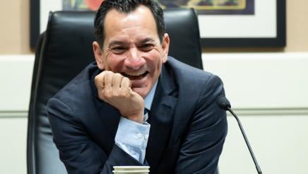 Speaker Emeritus Rendon leaning forward and sharing a light moment