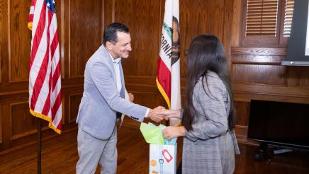 Speaker Emeritus Rendon shaking hands with participant