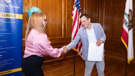 Speaker Emeritus Rendon shaking hands with participant