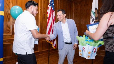 Speaker Emeritus Rendon shaking hands with participant