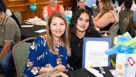 Program participant, with family member, displaying award