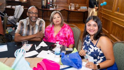 Program participant, with family members, displaying award