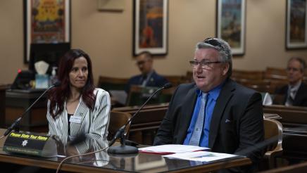 Witness providing testimony while fellow witness listens on