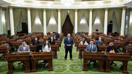 Asm. Solache standing in middle of seated students