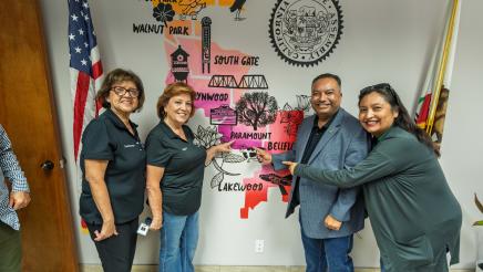 Asm. Solache and others pointing to mural of the 62nd Assembly District